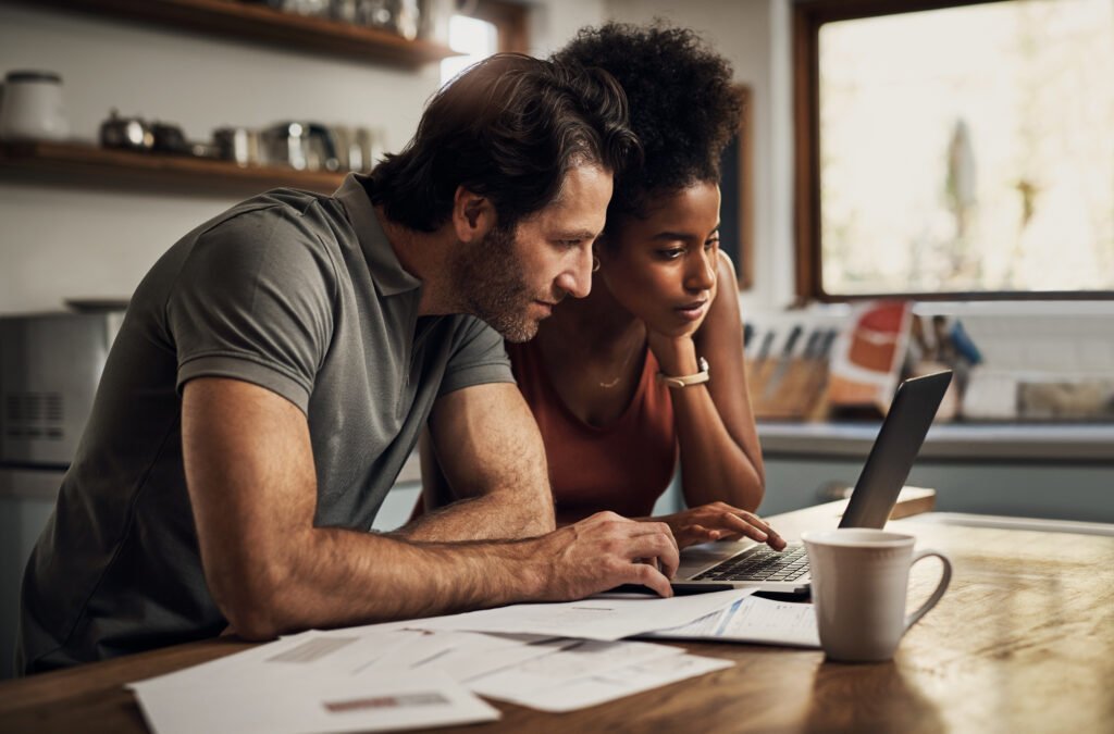 white man and black woman looking into flexible funding options with transition finance on the laptop